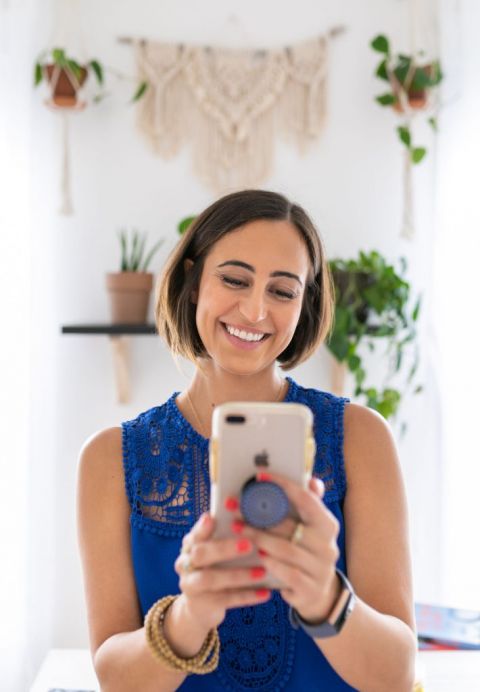 Oriana smiles while looking at her phone