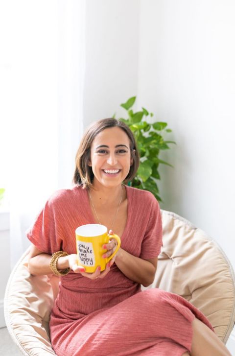 Oriana sits with a yellow coffee mug