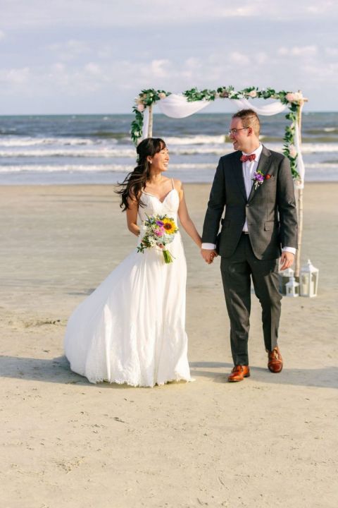 a newlywed couple celebrates their wedding on the beach