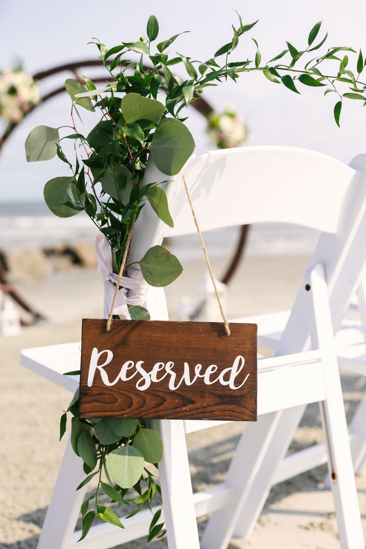 Chair, sign, and flowers set up for beach wedding in Charleston