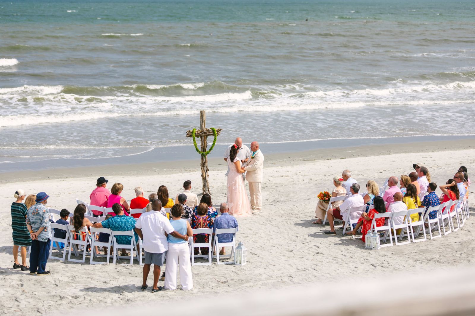 Folly Beach Wedding Ceremony at Pelican Watch Pavilion, you can see a high view of the ceremony on the beach with the ocean